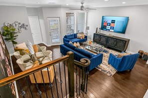 View of the lovely open space from the stairs. Beautiful cabinet offers storage 