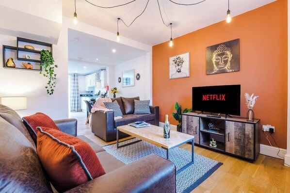 Large open plan living room equipped with a double sofa bed, plenty of room to sit down and a smart TV with Netflix.