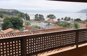 Varanda da casa com vista para o mar e churrasqueira.