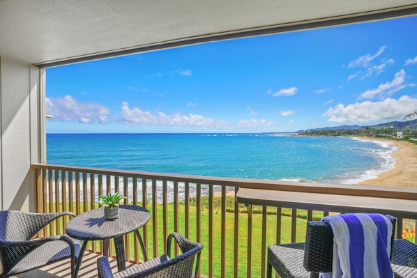 where turquoise waters meet the horizon, framed by lush tropical greenery in a serene setting.