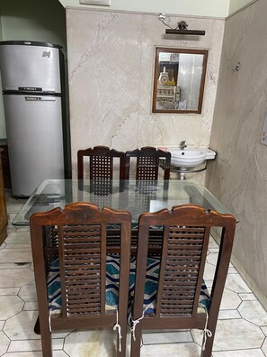 Lobby has a dining table for four, along with refrigerator.