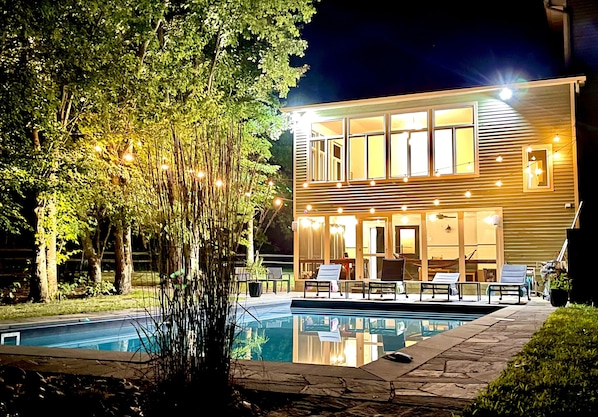 The pool area at night by the porch