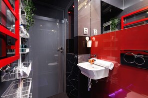 Vibrant bathroom with bold red tiles and sleek fixtures.
