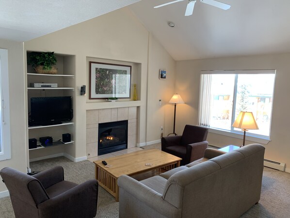 Spacious living room with vaulted ceiling and gas fireplace. 