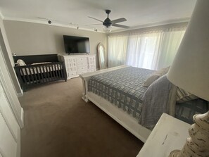 Master bedroom with large TV and crib