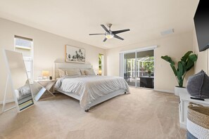 The Primary Suite has separate sliders to the lanai, king-size bed and Smart TV.
