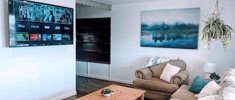 Living room with lots of seating and a 65in Smart Roku TV 
