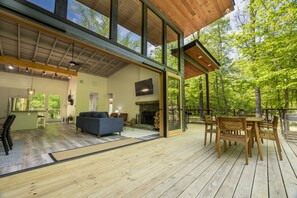 Deck facing interior cabin with open wall and outdoor seating. 
