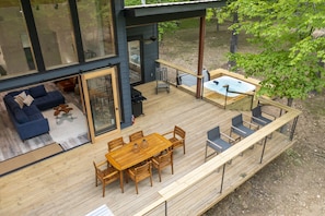 Far right side of deck showing hot tub & barstools overlooking horseshoes below.