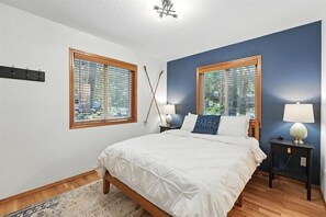 Cozy queen bed with soft linens for a restful stay after outdoor adventures.