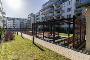 View of the building exterior with modern apartments and green spaces.
