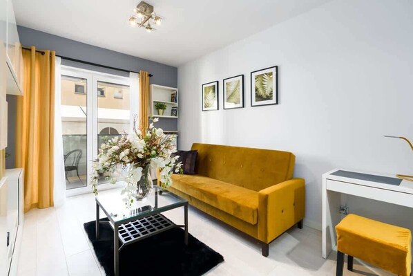 Cozy living room with a yellow sofa, coffee table, and modern decor.

