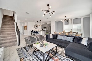 Bright living area of the townhouse in Kissimmee Florida - Open layout seamlessly connecting the living area to the kitchen and dining area - Stylish, contemporary furnishings enhancing the aesthetic - Entertainment hub with a Smart TV