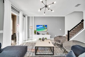 Enchanting living area of the townhouse in Kissimmee Florida - Stylish furniture arrangement providing comfort and a cohesive look - Easy access to outdoor with seating and pool - Well-chosen lighting fixtures adding both functionality and charm