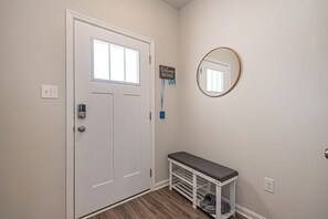 Front Door has a shoe bench and mirror. Smart lock