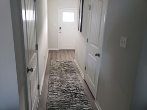 Entry Way has a coat closet with 2 umbrellas and shoe bench plus 1/2 bath