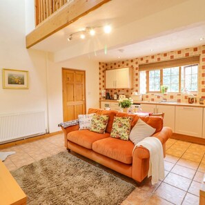 Living area and fully fitted kitchen with mezzanine above.