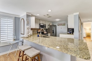 Luxury Fully Equipped Kitchen with Stunning Granite Countertops, Stainless Steel Appliances, and Bar Stool Seating for 2