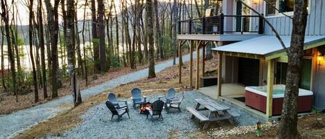 Lake Toxaway view with hot tub, fire pit and picnic table to create the atmosphere that enhances your next getaway to the mountains. All within reach of the ping pong table in the garage. Enjoy drinks by the fire while watching the sun set over the lake.