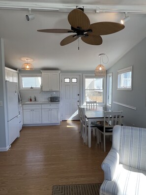 Kitchen with dining table and exit to side porch and outdoor shower