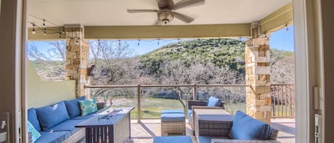 Fabulous covered patio with comfortable seating, a propane grill, and a propane glass fire pit with amazing views of the Guadalupe river!