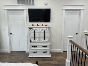 Loft area with TV, bathroom, and walk in closet