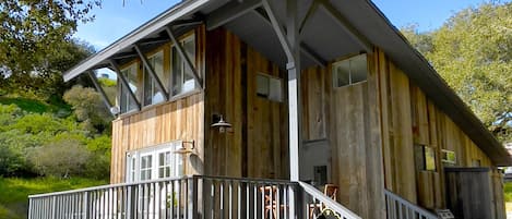 Walkway up to the guest house deck. Outdoor grill, picnic table, barrel table.