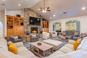 Spacious living area featuring a cozy fireplace and a large screen TV, perfect for relaxing or entertaining.
