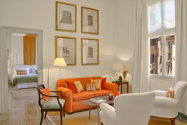 The bright living room of the Menta apartment with antique prints above the sofa.