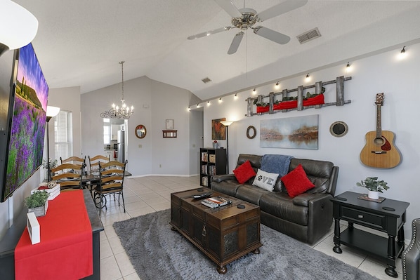 Beautiful living room w/70" TV, farmhouse table, dual reclining sofa & chair.