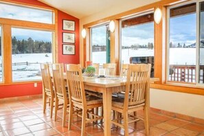Dining room directly off the kitchen surrounded by windows.