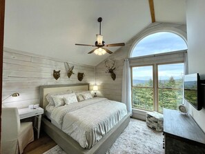 Master bedroom- king bed, smart tv, desk area, whitewashed walls and mtn views