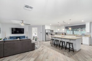 open floor plan living room + kitchen w/ breakfast bar