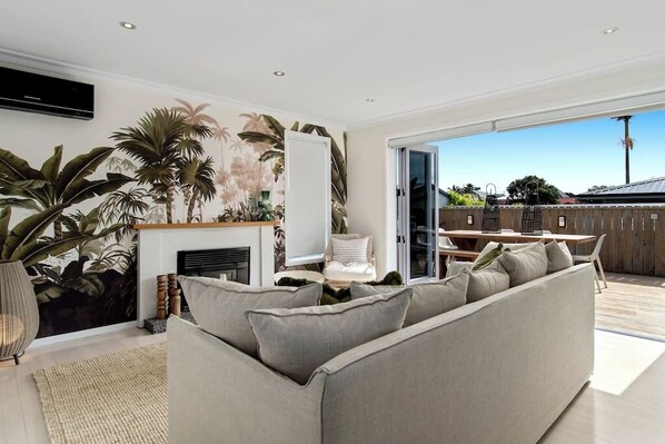 Designer furnishings in open plan lounge flowing to deck area