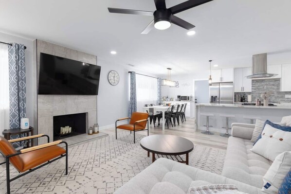 Large living room with plenty of comfortable seating. 75" Samsung smart TV. Remote-controlled candles in the fireplace.