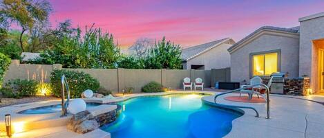 Perfectly manicuredd back yard oasis with sparkling play pool with spa