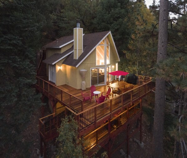 Twilight Aerial view highlighting large upper wraparound deck and lower veranda.