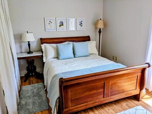 Queen bed in bedroom of primary apt/unit. Room has dresser and walk-in closet.