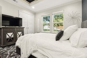 Comfortable queen bed with ceiling fan and smart TV