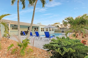 Backyard has tropical landscaping surrounding the pool