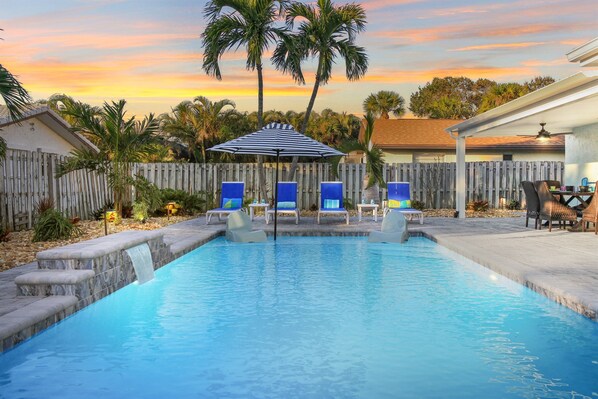 Heated Salt Water Pool with fountain and sun shelf with loungers and umbrella