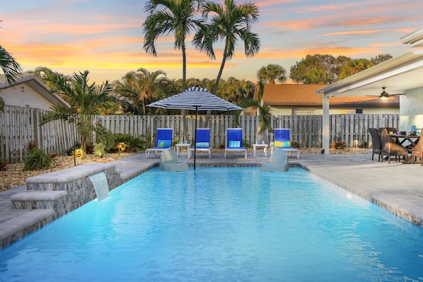 Heated Salt Water Pool with fountain and sun shelf with loungers and umbrella
