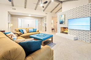 Spacious living room with vaulted ceilings and 65" smart TV