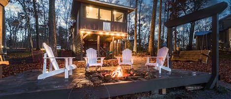 The back of the Tiny House featuring the lake and fire pit.