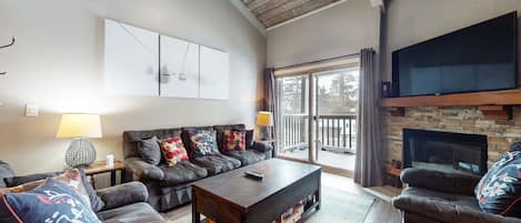 Open living space with fireplace, TV, and balcony