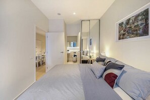 A second bedroom with a queen sized bed & plush pillows.