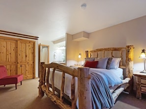 Relax in the distinctive master bedroom with a custom-built log bed frame