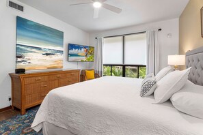 Primary bedroom with a king bed, ceiling fan and TV.