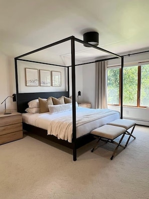 The Primary Bedroom boasts a king size canopy bed and sweeping views of two sides of the property.