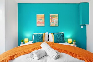 Double bedroom with soft neutral decor and a wardrobe.